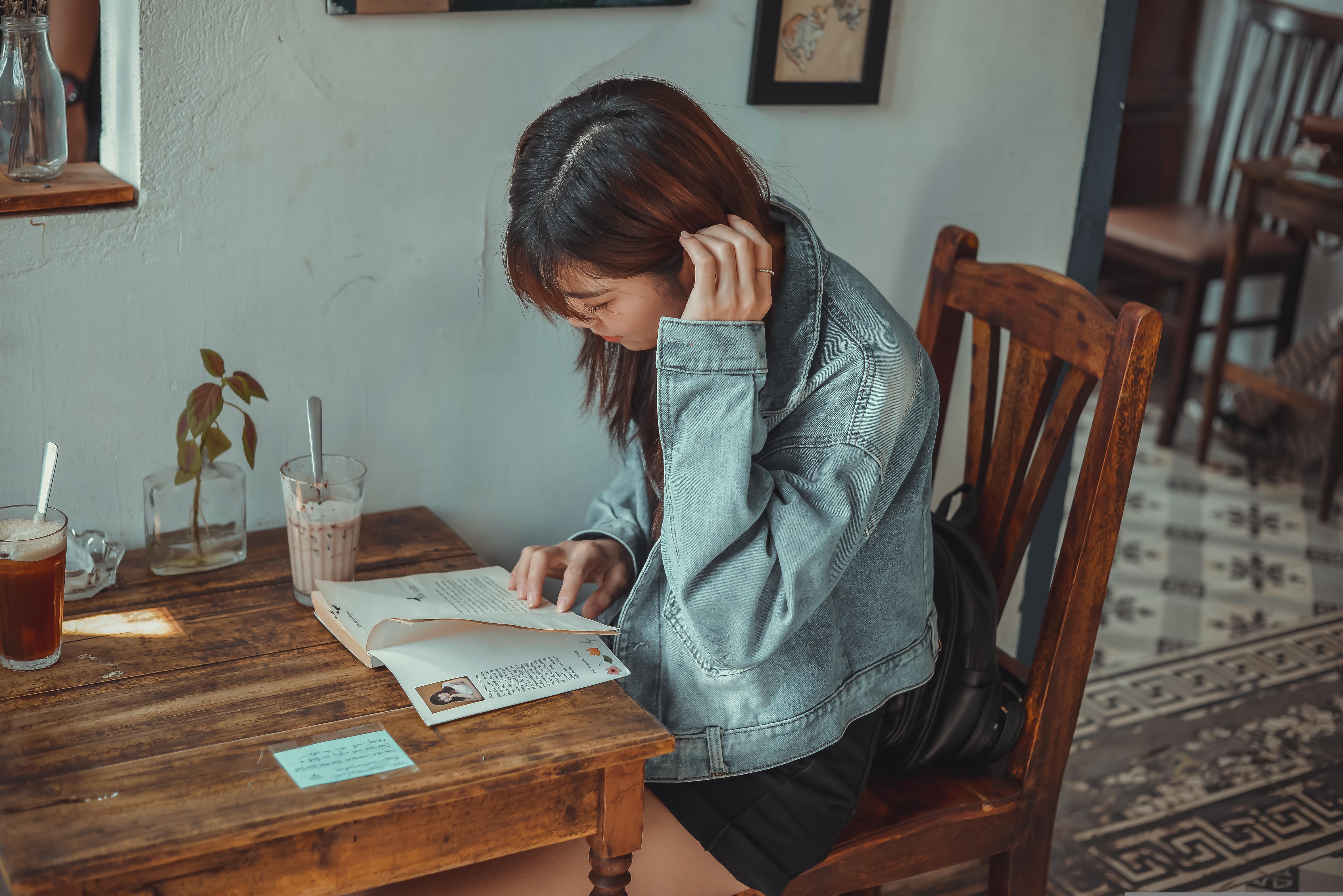 A guest reading at Table & Tales — warm wooden table, natural afternoon light